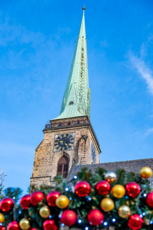 A festive scene with Christmas decorations in the foreground and the Cathedral of St. Bartholomew in Plzen, Czech Republic, in the background. A charming mix of tradition and holiday spiritの写真素材