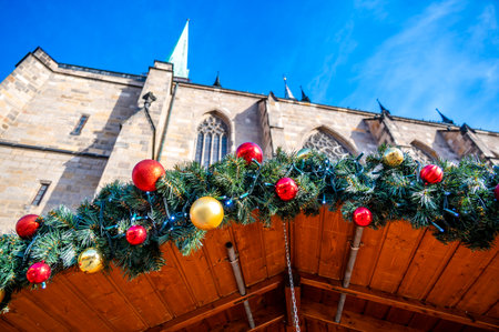 A festive scene with Christmas decorations in the foreground and the Cathedral of St. Bartholomew in Plzen, Czech Republic, in the background. A charming mix of tradition and holiday spiritの写真素材