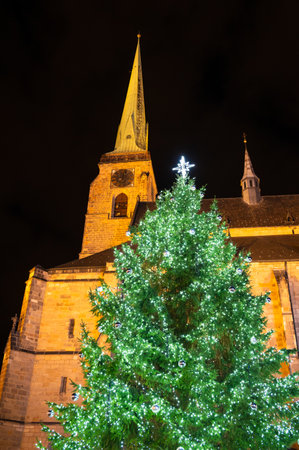 A festive scene with Christmas decorations in the foreground and the Cathedral of St. Bartholomew in Plzen, Czech Republic, in the background. A charming mix of tradition and holiday spiritの写真素材