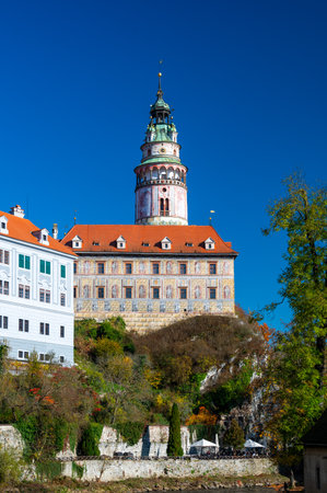 Panoramic view of Cesky Krumlov, featuring the historic castle tower and the church of St. John of Nepomuk. The medieval town's charm is beautifully captured on a sunny dayの写真素材