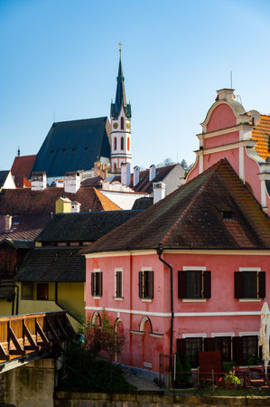 Church of St. Vitus in Cesky Krumlov surrounded by the historic town center. A sunny day with a clear blue sky highlights the charm of this UNESCO-listed medieval destinationの写真素材
