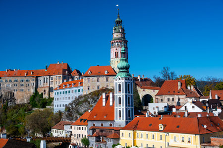 Panoramic view of Cesky Krumlov, featuring the historic castle tower and the church of St. John of Nepomuk. The medieval town's charm is beautifully captured on a sunny dayの写真素材