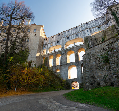 Cloak Bridge in Cesky Krumlov captured at sunset, with warm light illuminating the historic architecture. A stunning view of this UNESCO site during a tranquil eveningの写真素材