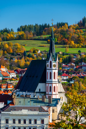 Church of St. Vitus in Cesky Krumlov surrounded by the historic town center. A sunny day with a clear blue sky highlights the charm of this UNESCO-listed medieval destinationの写真素材