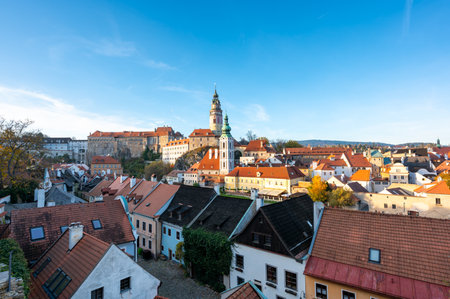 Panoramic view of Cesky Krumlov, featuring the historic castle tower and the church of St. John of Nepomuk. The medieval town's charm is beautifully captured on a sunny dayの写真素材