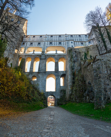 Cloak Bridge in Cesky Krumlov captured at sunset, with warm light illuminating the historic architecture. A stunning view of this UNESCO site during a tranquil eveningの写真素材