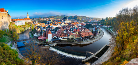 Panoramic view of Cesky Krumlov, showcasing the UNESCO-listed historic center surrounded by the Vltava River in a meander. A sunny autumn day highlights the town's charm.の写真素材