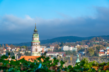 Panoramic view of Cesky Krumlov, featuring the historic castle tower and the church of St. John of Nepomuk. The medieval town's charm is beautifully captured on a sunny dayの写真素材