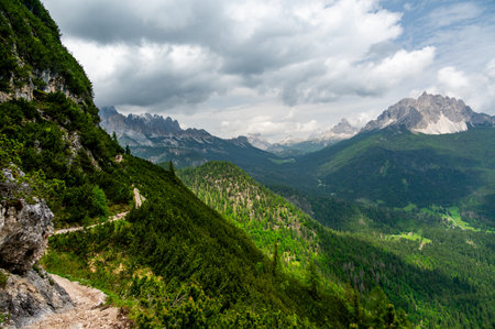 Breathtaking view of forests, mountains, and valleys in the Italian Dolomites (Dolomiti, Dolomiten). Captured from a scenic trail along a rocky ledge. Stunning alpine natureの写真素材