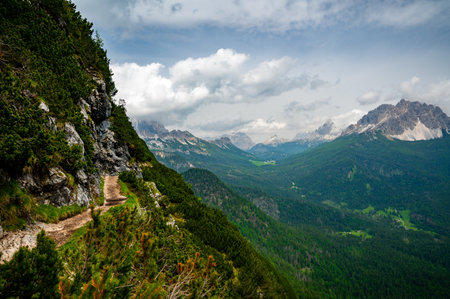 Breathtaking view of forests, mountains, and valleys in the Italian Dolomites (Dolomiti, Dolomiten). Captured from a scenic trail along a rocky ledge. Stunning alpine natureの写真素材