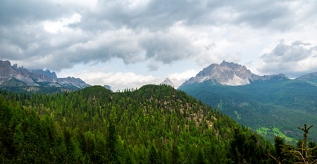 Breathtaking view of forests, mountains, and valleys in the Italian Dolomites (Dolomiti, Dolomiten). Captured from a scenic trail along a rocky ledge. Stunning alpine natureの写真素材