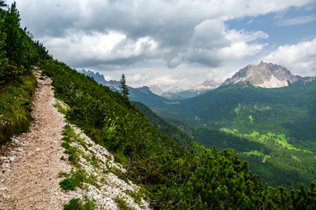Breathtaking view of forests, mountains, and valleys in the Italian Dolomites (Dolomiti, Dolomiten). Captured from a scenic trail along a rocky ledge. Stunning alpine natureの写真素材
