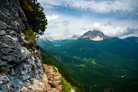 Breathtaking view of forests, mountains, and valleys in the Italian Dolomites (Dolomiti, Dolomiten). Captured from a scenic trail along a rocky ledge. Stunning alpine natureの写真素材