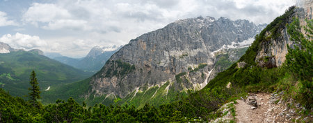 Breathtaking view of forests, mountains, and valleys in the Italian Dolomites (Dolomiti, Dolomiten). Captured from a scenic trail along a rocky ledge. Stunning alpine natureの写真素材