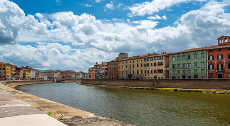 Colorful riverside buildings line the banks under bright summer skies in a warm Mediterranean atmosphere.の写真素材