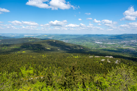 View from Jested mountain with the stone formation Virive stones in the foreground and the city of Liberec stretching in the background under a clear blue sky.の写真素材