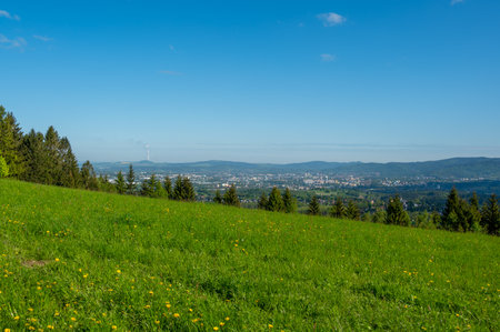 View of the city from nearby hills around mountain. Urban landscape surrounded by greenery and hills, typical northern Bohemia summer sceneryの写真素材