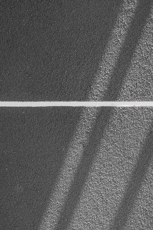 The light from the sun on a grey texture wall.