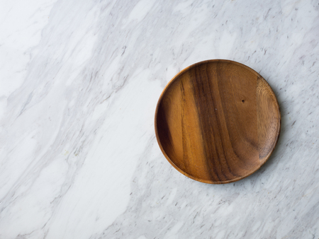 Wooden spoon, fork, soup poon and plate on white venus marble.の写真素材