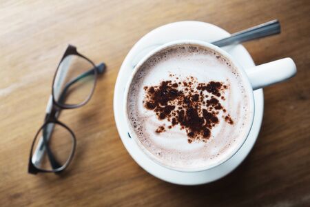 Coffee cup with glasses on wood tableの写真素材