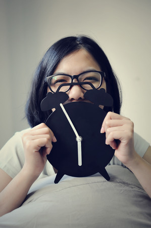 Happiness time of asian woman with alarm clock on white background.の写真素材