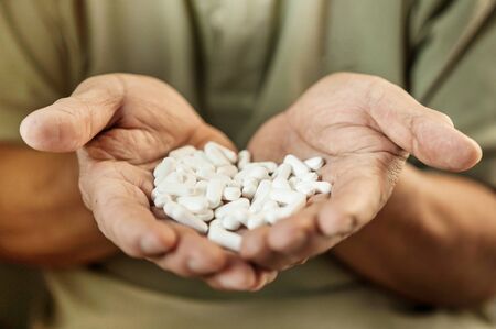 Close up, Hand is holding and showing some medicine pills or capsules, Selective focus.の写真素材