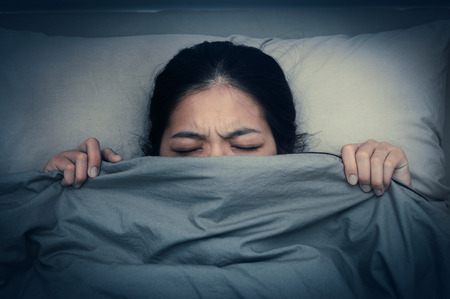 Young woman dont want to hear sound from alarm clocks. Asian woman having trouble with getting up early in the morning,の写真素材