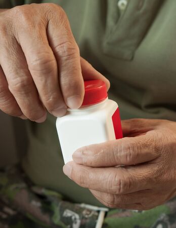 Old man opening the bottle of medicine.の写真素材