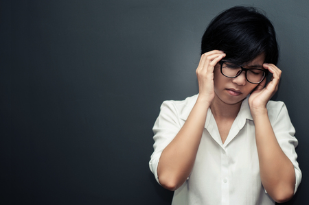 Close up of asian business  woman be ill. Glasses woman having headache. copy space.の写真素材