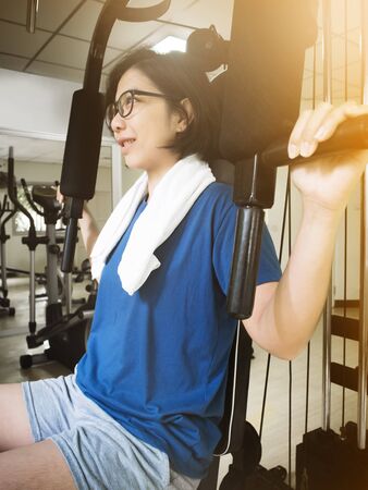 Asian woman working out with exercise machine in the gym.の写真素材
