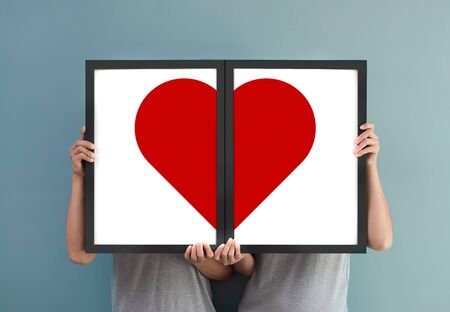 Valentine's day concept. Happiness of couple holding red heart in picture frames.の写真素材