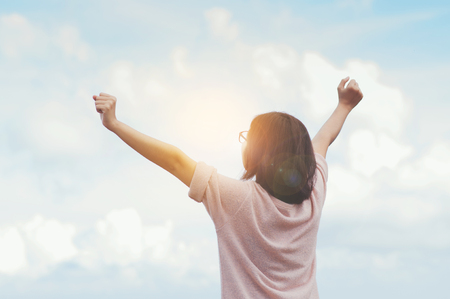 Relaxation, Hapiness, concept. Woman standing and feel freedom with arms stretched on blue sky background.の写真素材