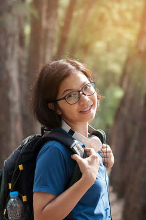 Happiness of Young Asian woman hiker with backpack and headphone in nature.の写真素材
