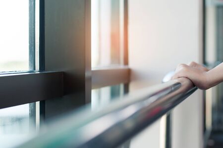 Close up of woman hands holding stainless  rail in a room.の写真素材