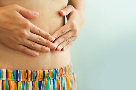 Close up woman hands on her belly. Stomachache of woman with copy space. Vintageの写真素材