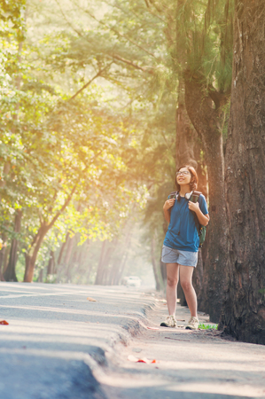Asian woman hiker with backpack standing and breathing fresh nature air. Happiness of girl and smiling on vacation.の写真素材