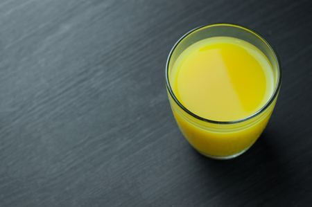 Close Up of orange juice in glass on wooden background.の写真素材