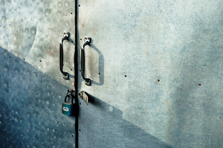 Close up Padlocks with old iron gate background with shade and shadow from sunlight. Copy space.の写真素材