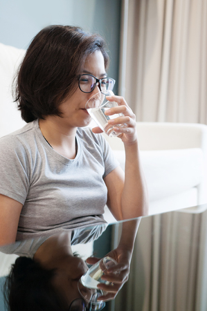Asian glasses woman drinking water.の写真素材