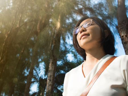 Beautiful young Asian woman relaxing and breathing in fresh air in autumn.の写真素材