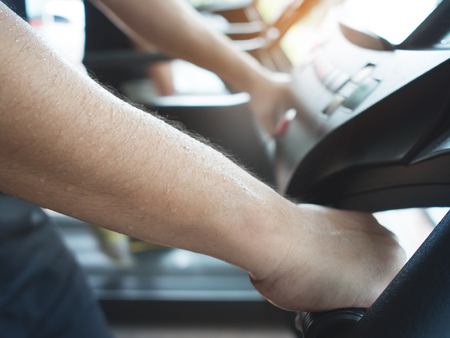 Close up sweat on man hands while working out on treadmill machine at a gym.の写真素材