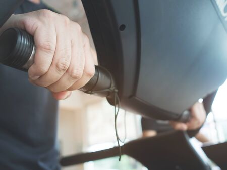 Close up man hands holding on treadmill machine while working out at a gym.の写真素材