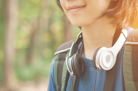 Happiness of Asian woman hiker with backpack and headphone is smiling on nature background.の写真素材