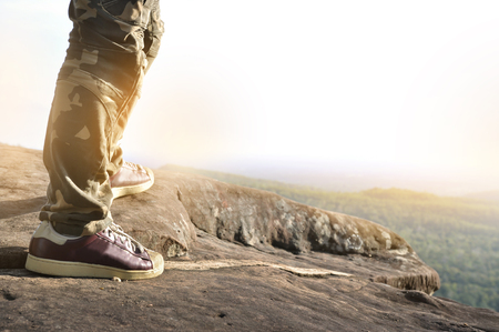 Close up of man standing on top of a mountain. Sucessful, struggle concept.の写真素材