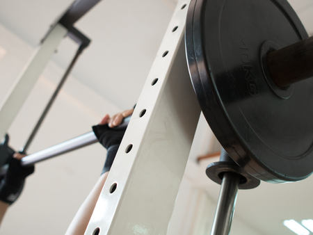Close up man hands wear gloves with barbell at the gym.の写真素材