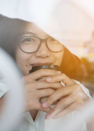 Relaxing of Asian woman smiling with cup of coffee.の写真素材