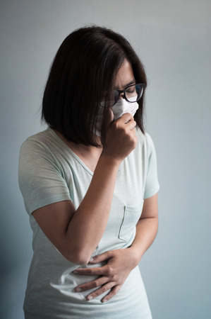 Illness, disease, cold  concepts.  Asian glasses woman has a cold and coughing. Girl with medical mask.の写真素材