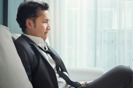 Exhausted, Illness, tired, stressed from overworked concepts. Businessman in grey suit thinking. Copy space.の写真素材