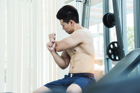 Muscular Asian man Stretching before workout at the gym. copy space.の写真素材