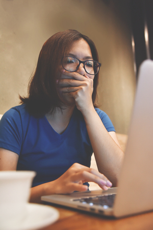 Asian eyeglasses Woman yawning. Sleepy, tired, exhausted from overworked.の写真素材